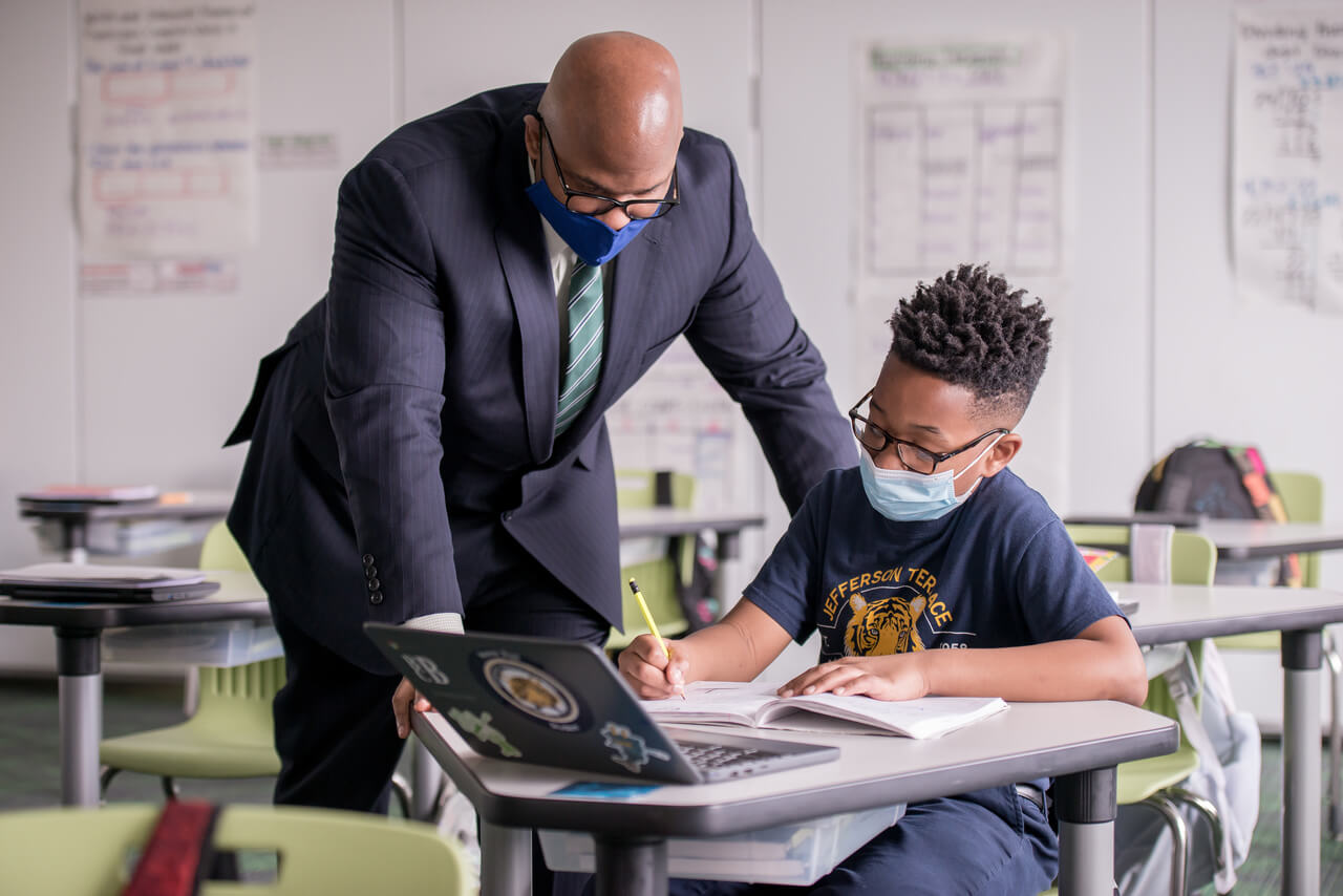 Dr. Sito Narcisse in a classroom with a student