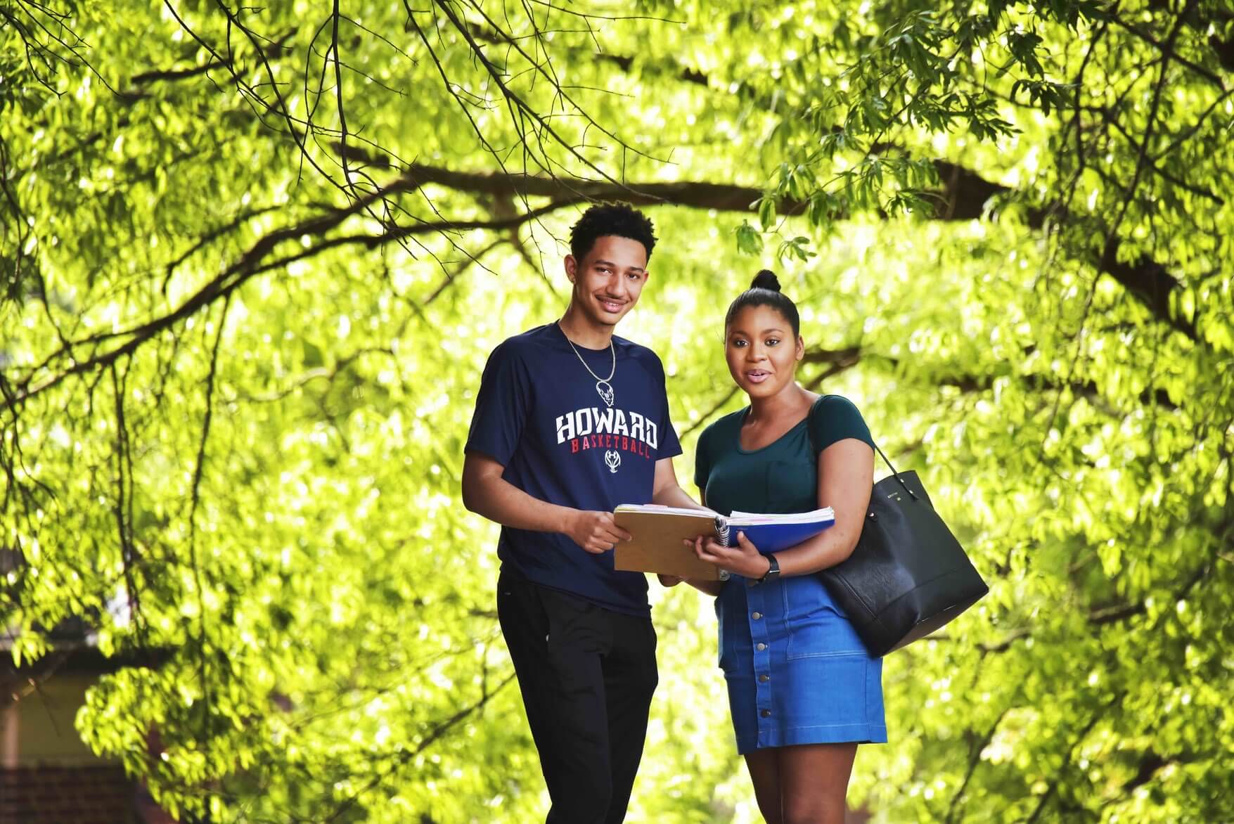 Howard students smile under green tree