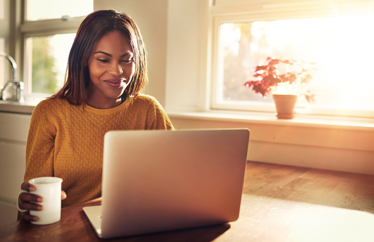 Woman in front of computer with coffee