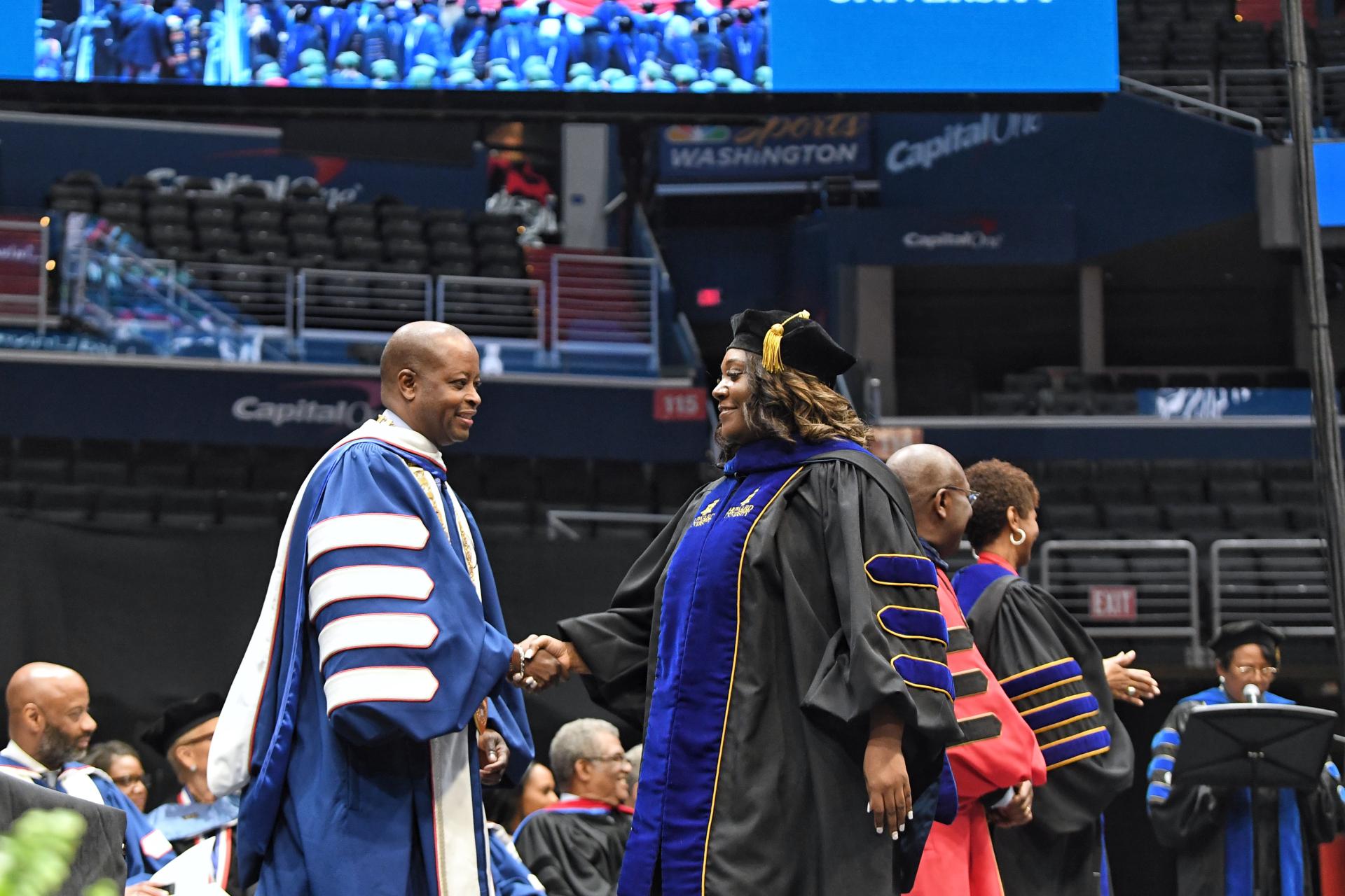 Dr. Frederick shakes a new graduate's hand