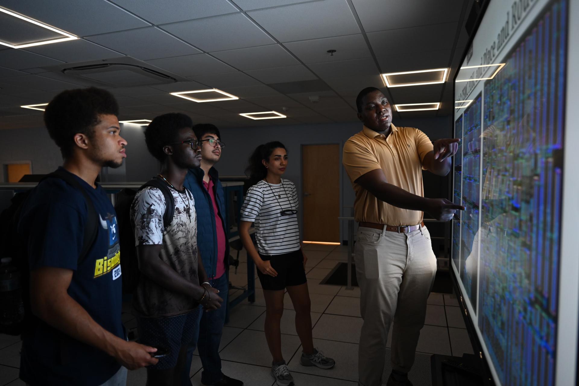 A College of Engineering and Architecture shows the microchip lab design to students during the lab’s ribbon-cutting ceremony. (Source: Howard University) 