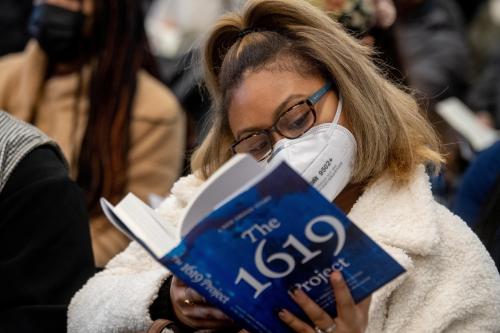 Student sneaks a peak at the "1619 Project" during a book discussion by author and journalism professor Nikole Hannah-Jones. -Justin D. Knight/Howard University