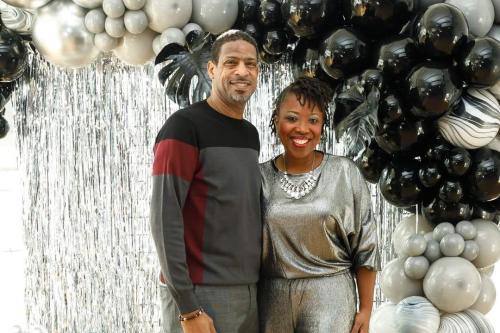 Marisha and Solomon Humphries standing by silver and black party decor