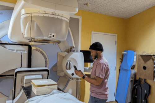 Medical Physics student stands in front of MRI machine