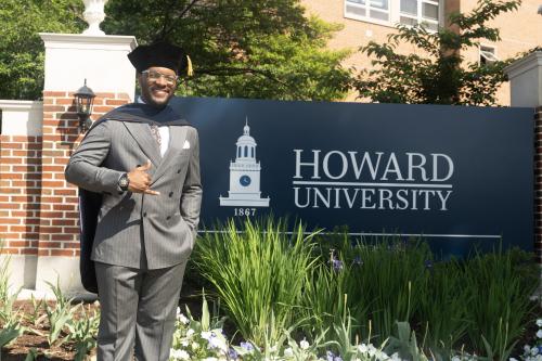 Arsene Frederic standing in front of a sign that says Howard University
