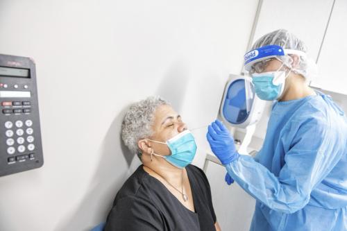 seated patient receives a treatment from a doctor through nose