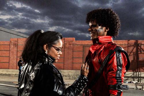 Marci Rodgers on the left fixing red jacket costume of actor who is playing Michael Jackson