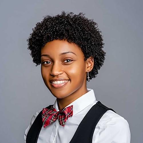 Kennedy Chastang wearing a black vest with a white button down and red tartan bowtie