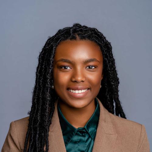 Ava Conyer wearing a brown blazer with a dark green button down shirt