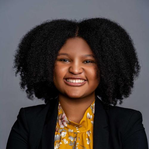 Morgan Jones wearing a black blazer with a yellow patterned blouse