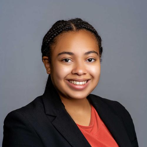 Gabrielle Wood wearing a black blazer with an orange shirt