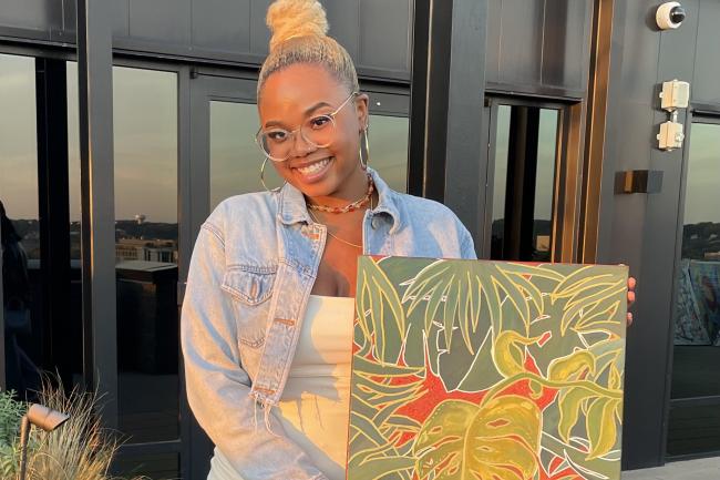 Black woman holding a painting 