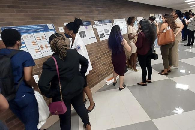 people standing in hallway looking at health posters on wall