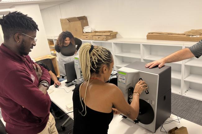 In the Moorland-Spingarn Research Center, students look onto a device used to digitize items and documents to preserve them