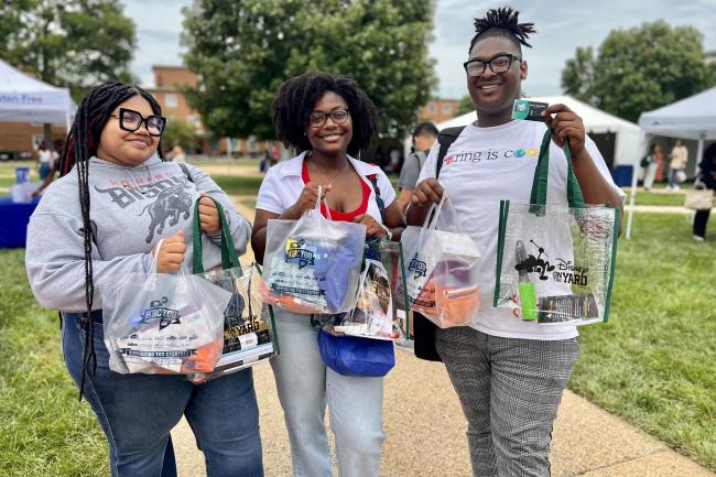 Students hold swag bags during CorpComm 2023 on the Howard University Yard