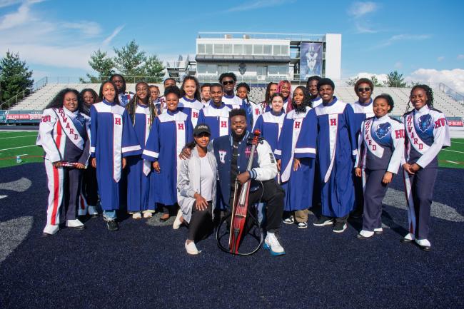Showtime marching band poses with Professor Jami Ramberan and musician Kevin Olusola