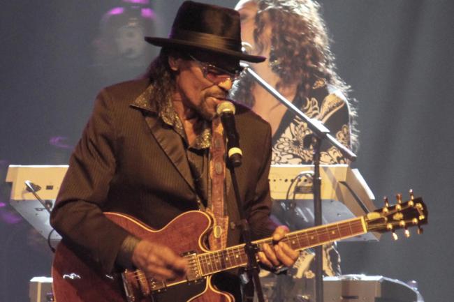 Chuck Brown performing on stage with his guitar
