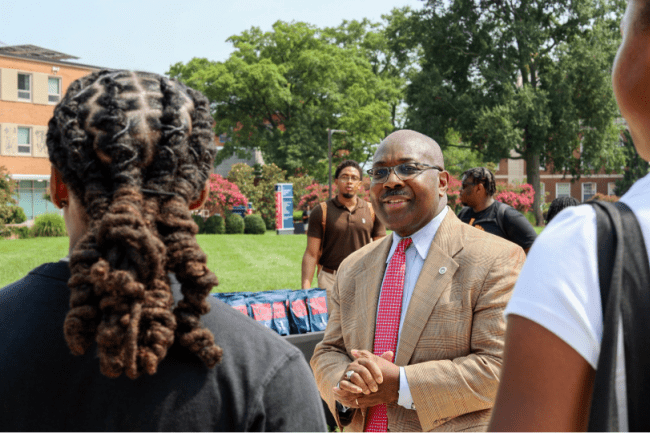 Students outside on Howard's campus with Provost Anthony Wutoh