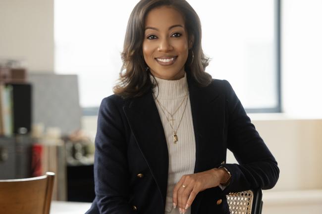 Jasmine Gurley seated wearing a white turtleneck and dark blazer