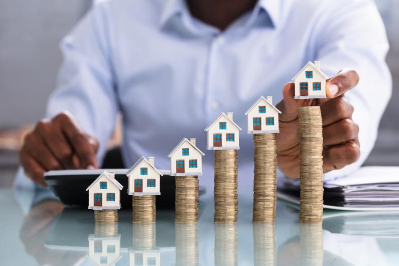 An iStock image of quarters with houses being stacked is part by height 