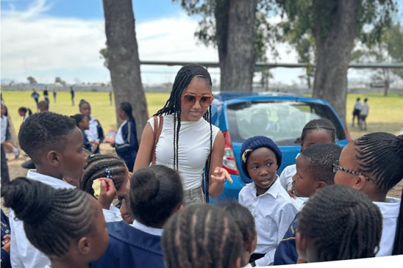 A school of social work student speaking to children outdoors in Cape Town