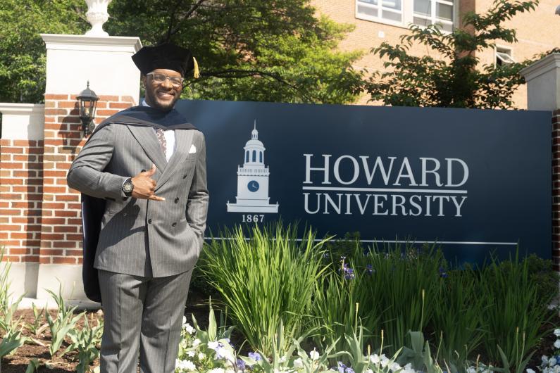 Arsene Frederic standing in front of a sign that says Howard University
