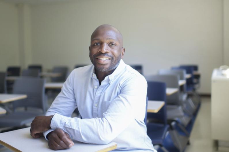 Brandon Hogan_philosophy professor, seated in a classroom