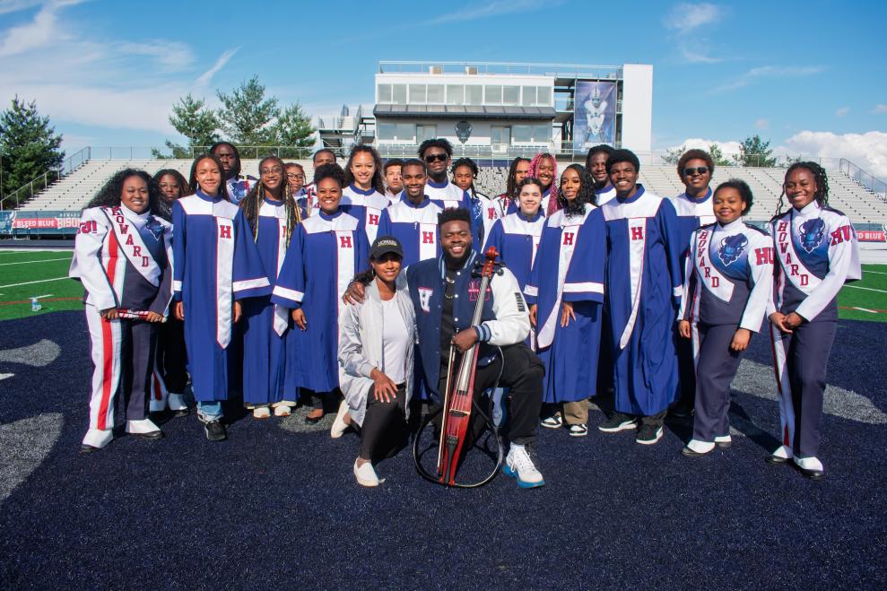 Showtime marching band poses with Professor Jami Ramberan and musician Kevin Olusola