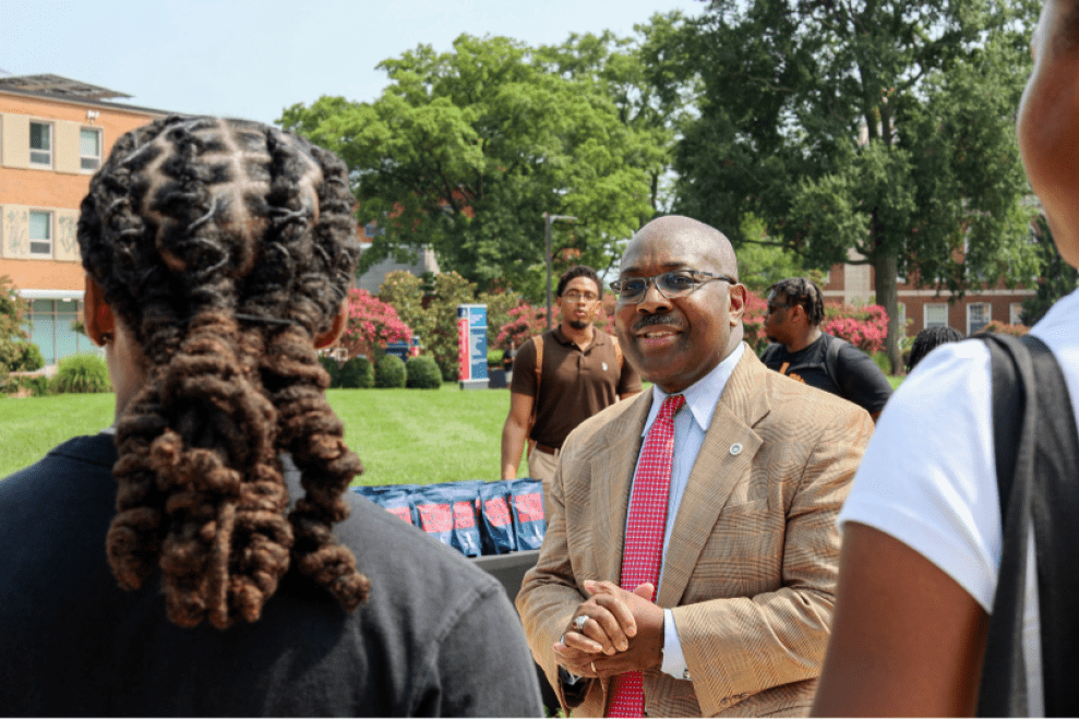 Students outside on Howard's campus with Provost Anthony Wutoh