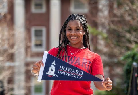Howard student with a pennant