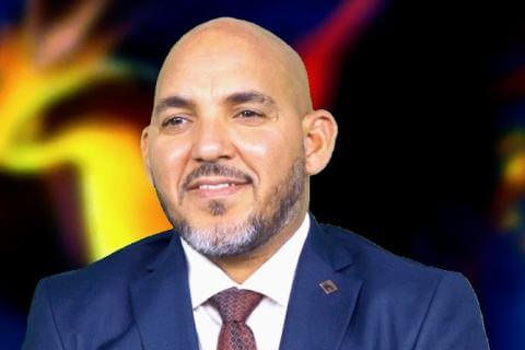 A man in a blue suit with a white tie and a tie on looking off to the left side of the picture