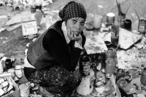 Mary Lovelace O'Neal in her studio crouching down around an array of art supplies