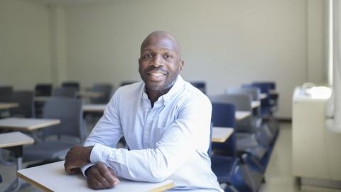 Brandon Hogan_philosophy professor, seated in a classroom