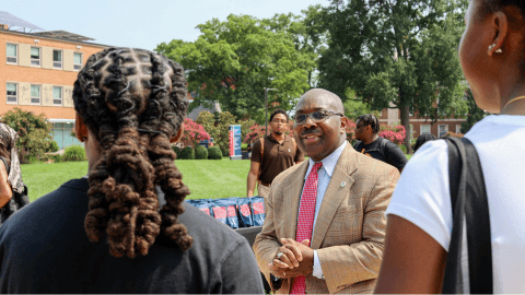 Students outside on Howard's campus with Provost Anthony Wutoh