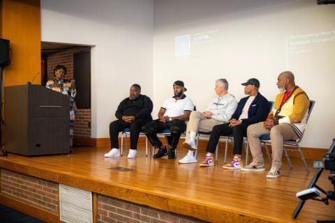 Panel with five men seated side by side at Blackburn Digital Auditorium at screening at "How to Change the World" documentary