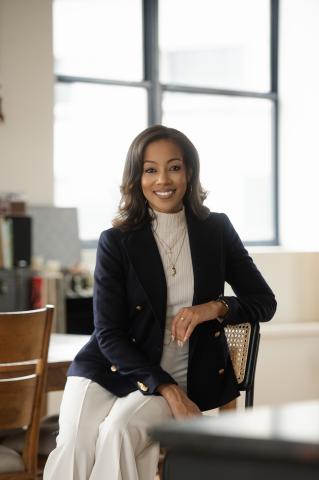 Jasmine Gurley seated wearing a white turtleneck and dark blazer