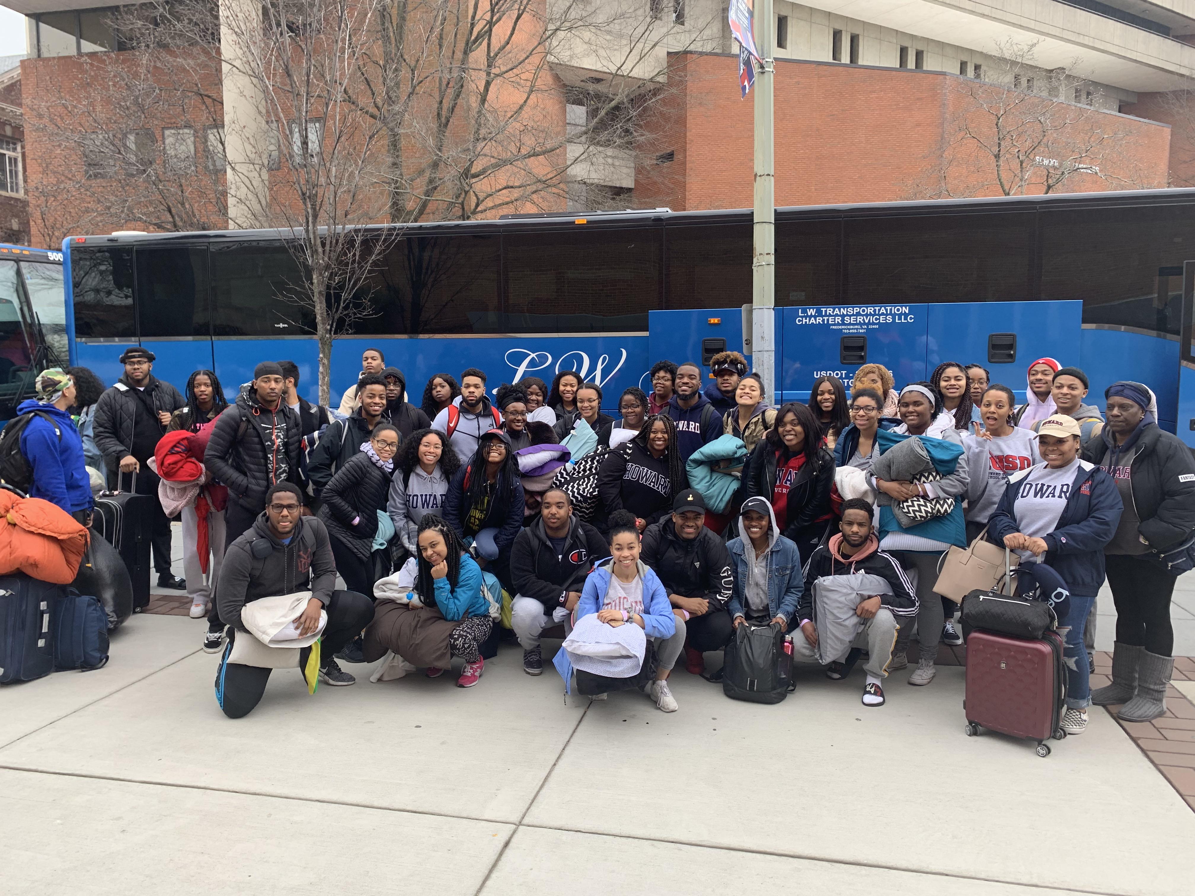 students in front of bus for alternative spring break