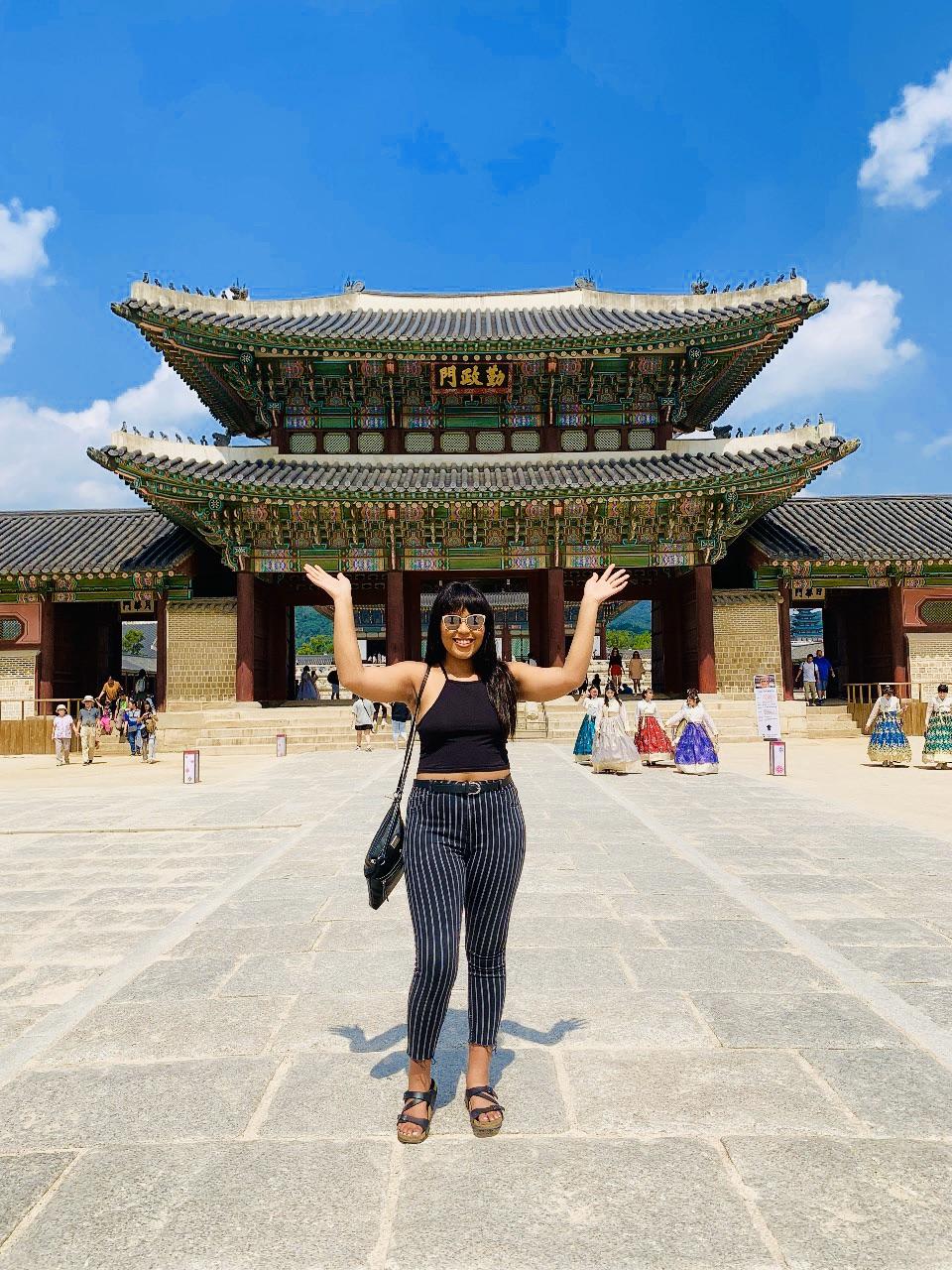 student in front of pagoda-style building