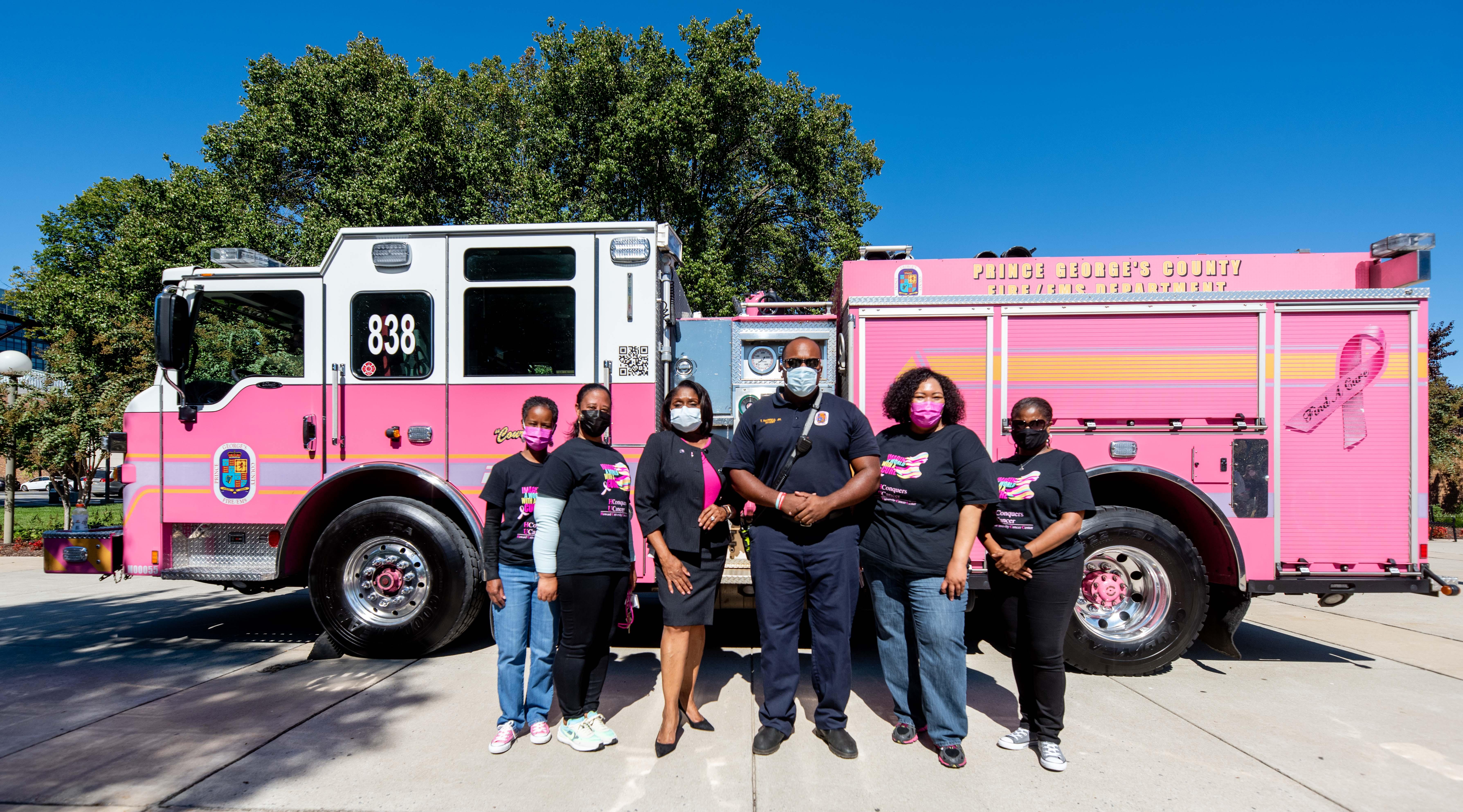Howard University representatives in front of pink fire truck for breast cancer awareness