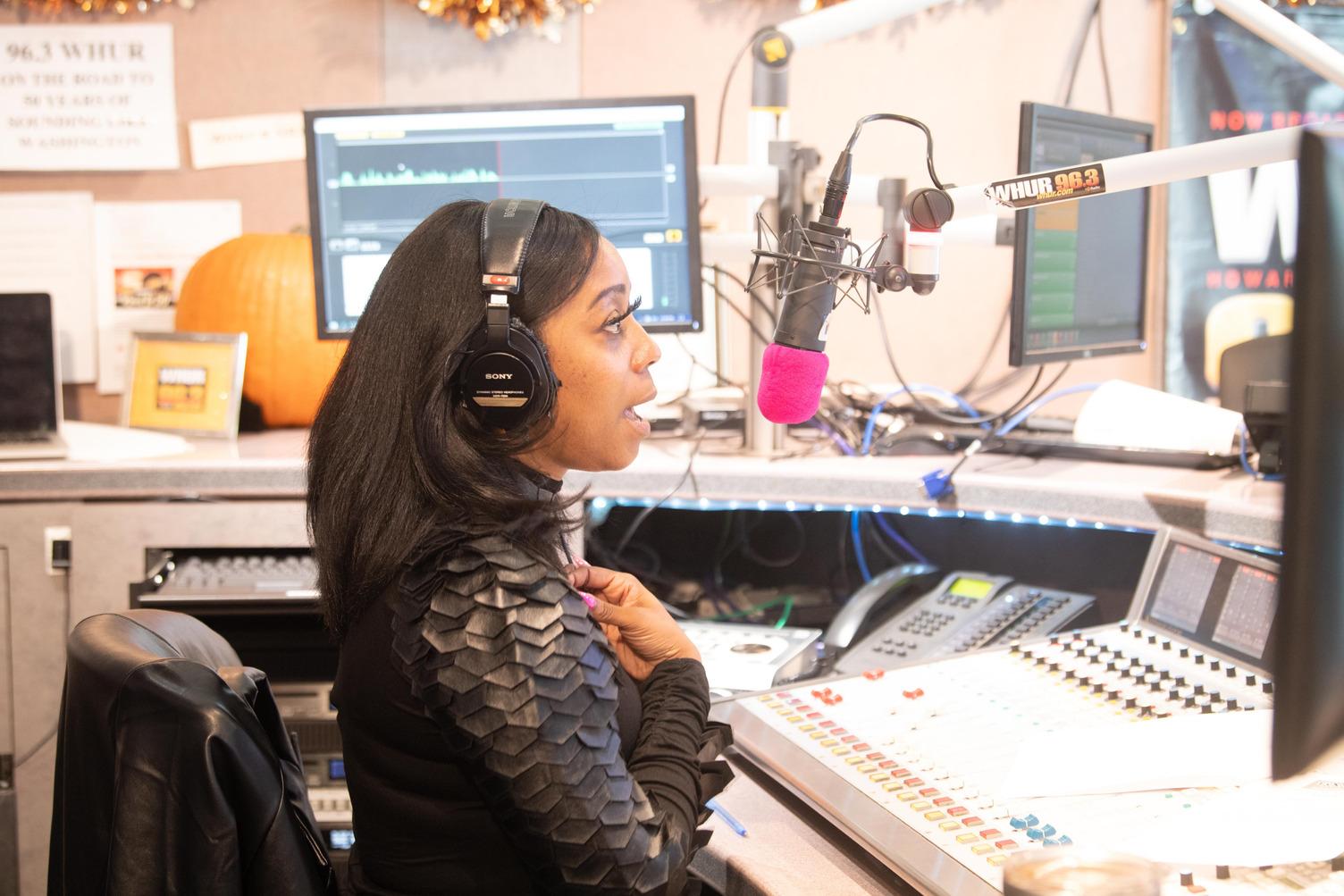 Woman speaking by radio wearing headphones for radiothon