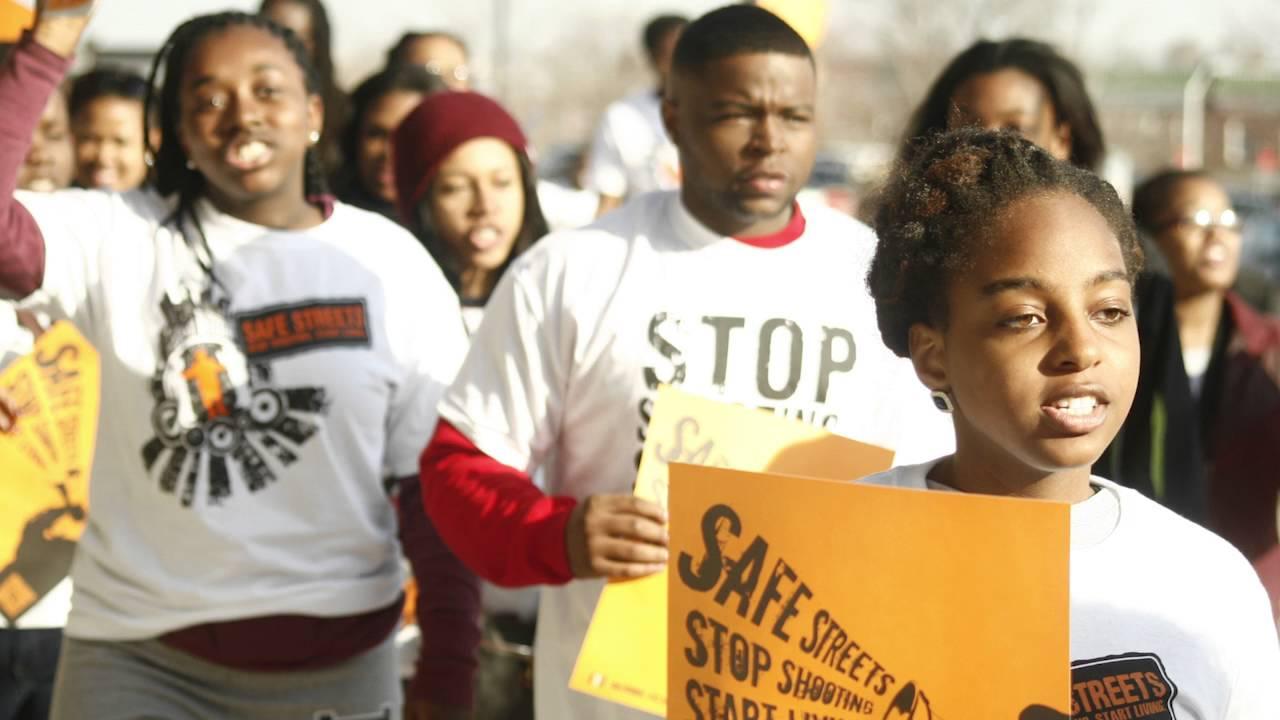 Students in alternative spring break marching with signs