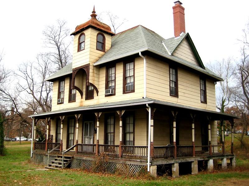 large beige house with wraparound balcony