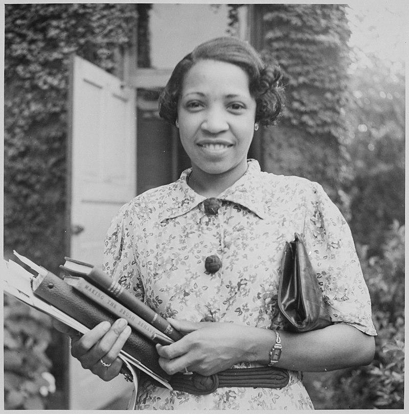 Lois Mailou Jones holding books, b/w photo 