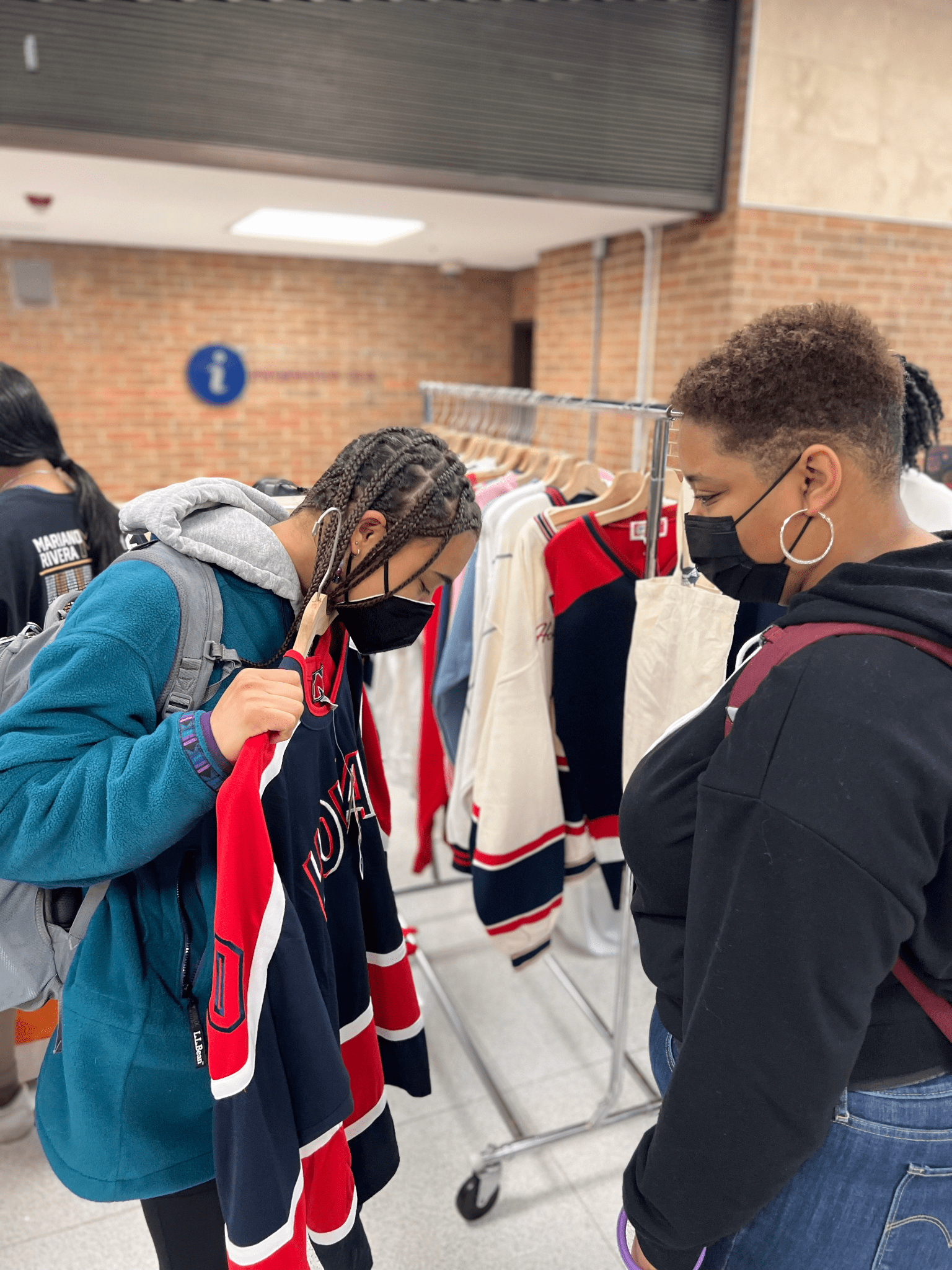 Students try on clothing from small businesses