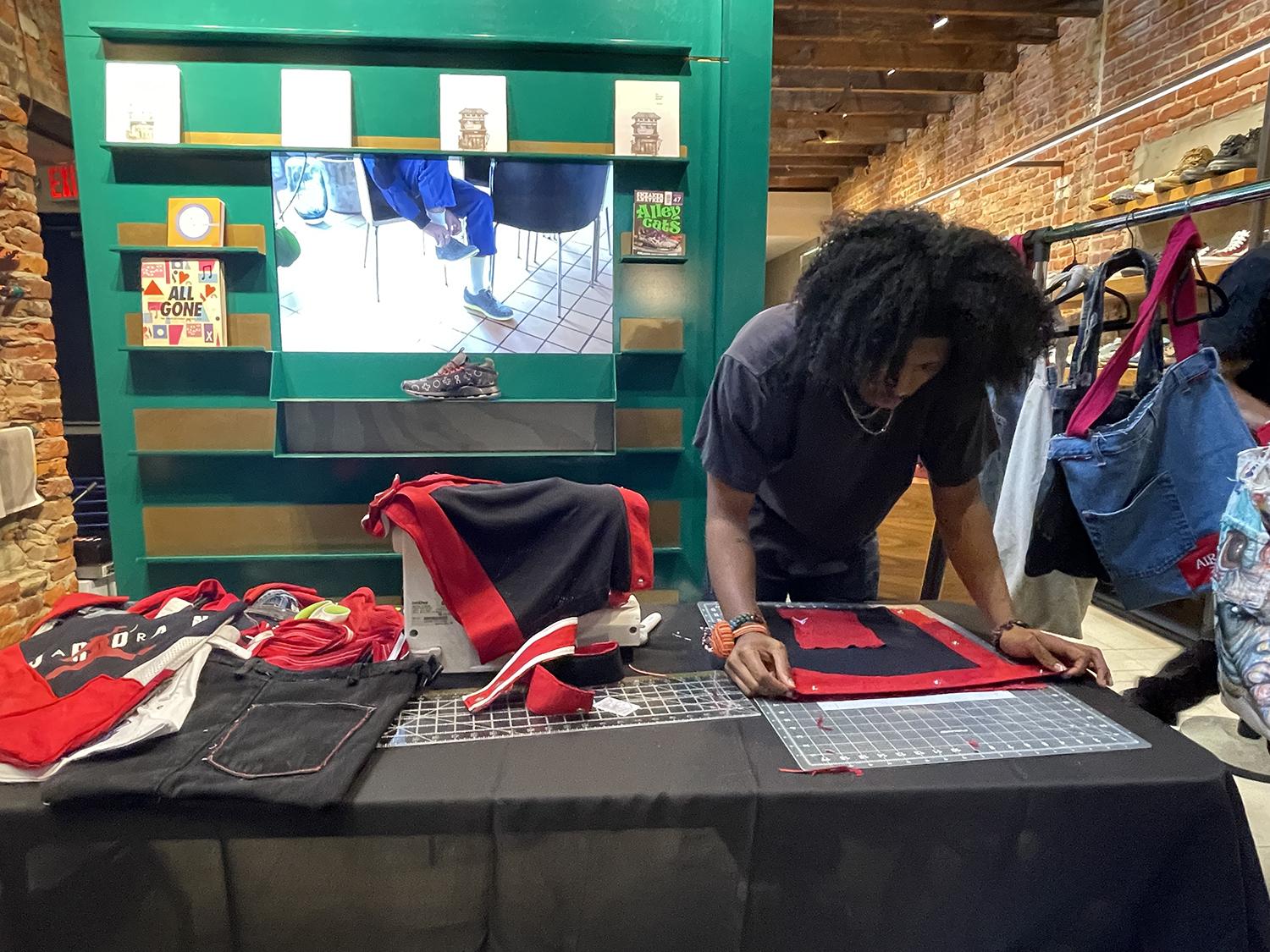 male student working on a fashion design on a table