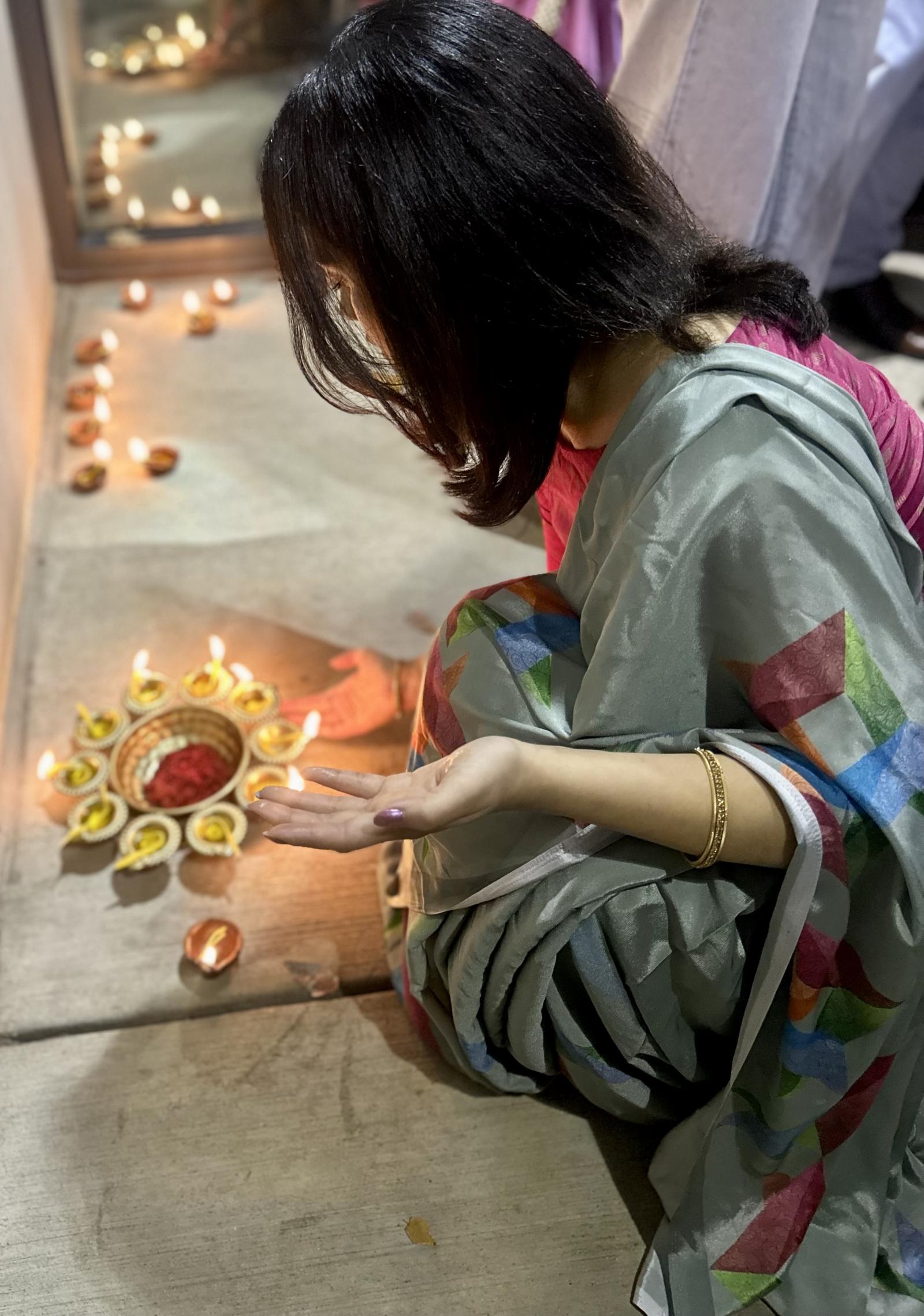 Reeja Shrestha places candles for Diwali onto its rightful spot on the side of the office of the dean of the chapel