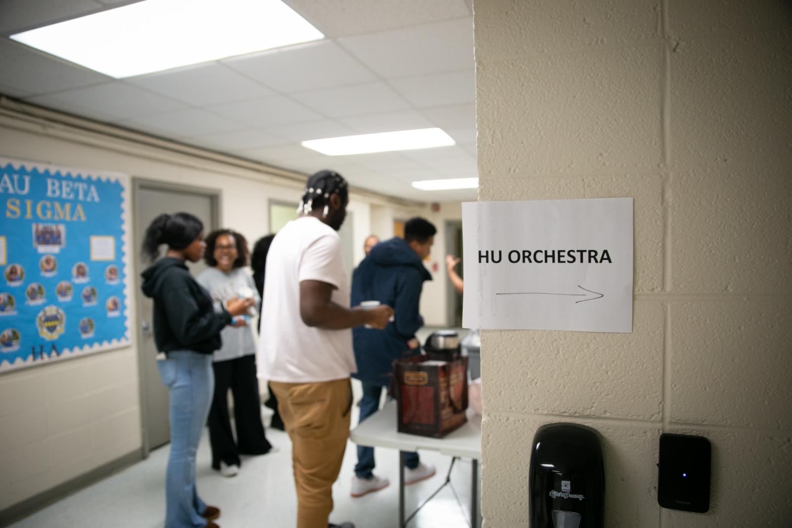 Gathered in the hallway outside of the practice room, HU Orchestra musicians enjoy refreshments during their brief break.
