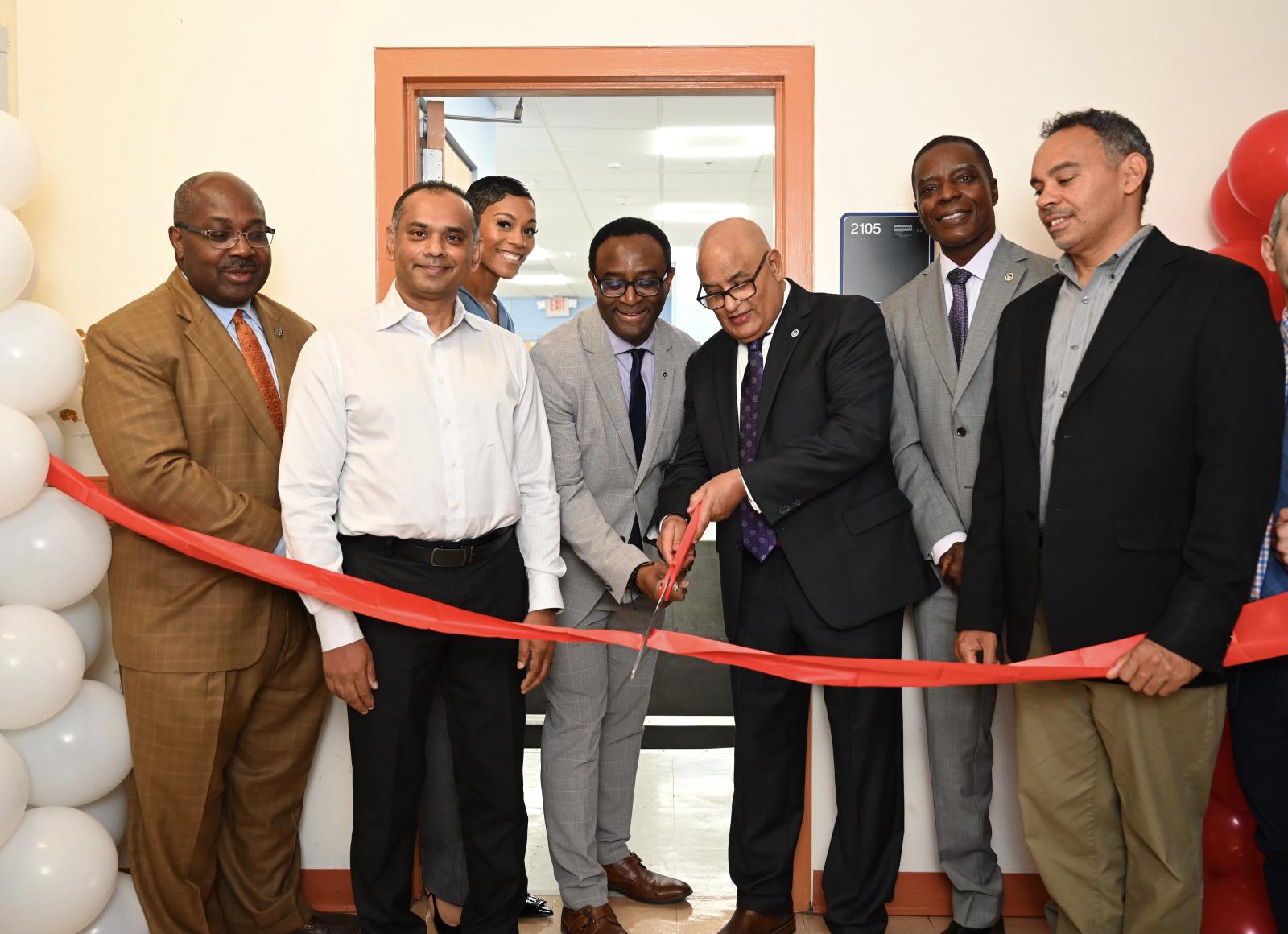 Ahmed Rubaai, Ph.D., (center) cuts the ribboned-off entrance outside of the state-of-the-art laboratory. From L to R: University Provost Anthony K. Wutoh (R.Ph., Ph.D.), CEA professor Imtiaz Ahmed, Tracy B. Ellis of Apple, President Vinson, Ahmed, CEA dean John M.M. Anderson (Ph.D.), and Michael Smith of Apple. (Source: Howard University)