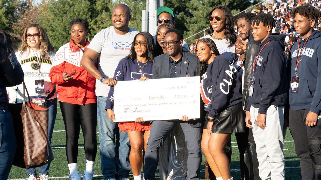 At Saturday’s Homecoming football game, Howard University President Ben Vinson III (center) presents a $115,000 fundraising check with members of the Class of 2004.