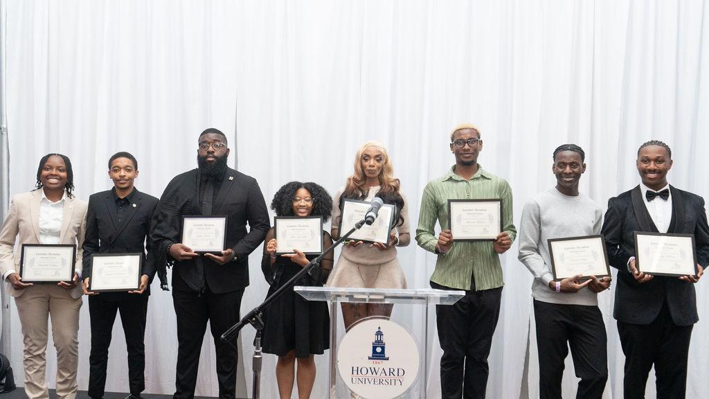 This year’s nine Lavender Scholarship recipients pose together with a certificate to recognize their scholarship prize money. In no order:  Jeremy Allman, Marvens Belidor, Tiana Malcolm, Joshua Burns, Chloe McNeill, Joshua Odam, Jasean Robertson, Elisabeth Wilson, and Ivann Angu. 